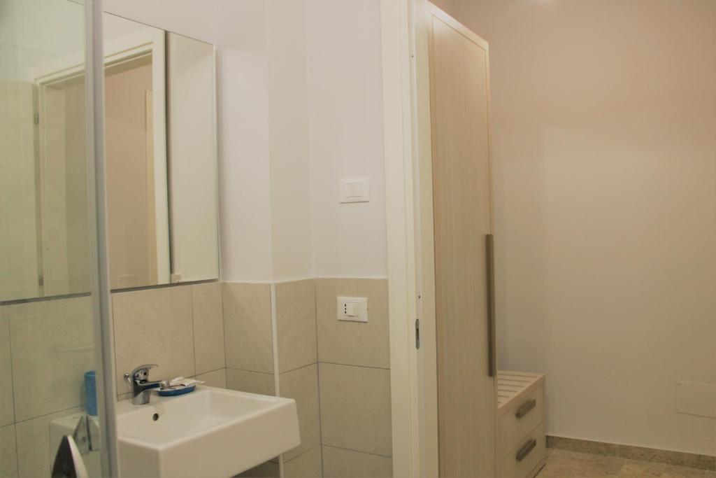 a white bathroom with a sink and a mirror at Zibibbo Beach Apartments - Trapani in Trapani