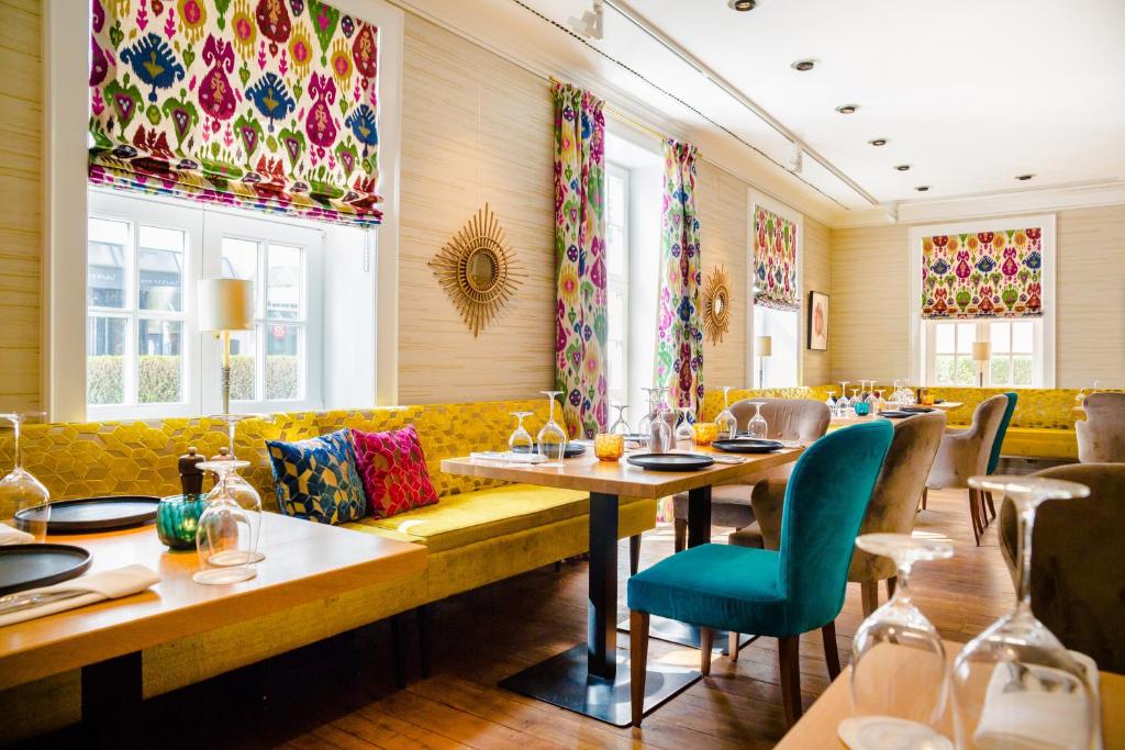 a restaurant with couches and tables and chairs at Hotel Stadt Hamburg in Westerland
