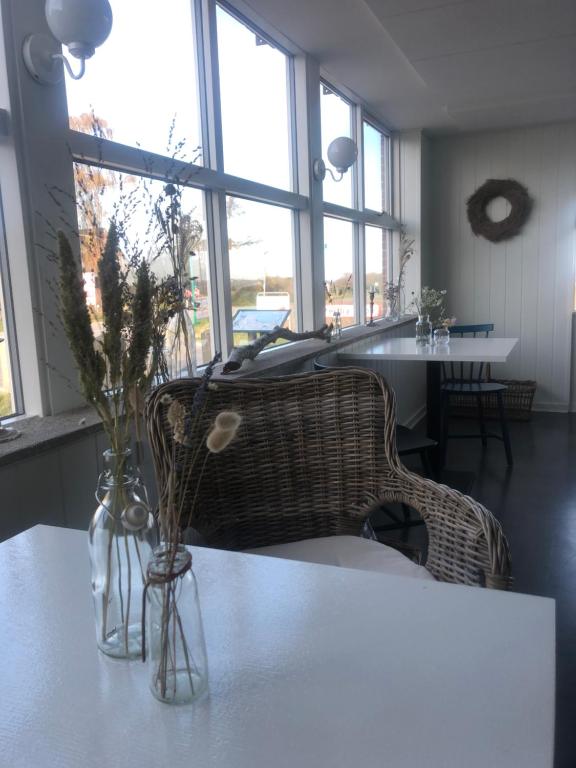 a living room with a table and chairs and windows at Samsted in Middelfart