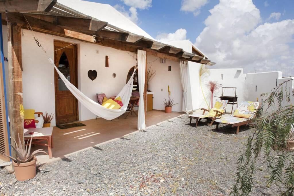 a hammock on the patio of a house at Alegría Aire - Eco Retreat Finca Artis Tirma in Tarajalejo