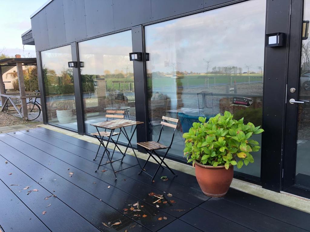 a balcony with a table and chairs and a view of a tennis court at Samsted in Middelfart