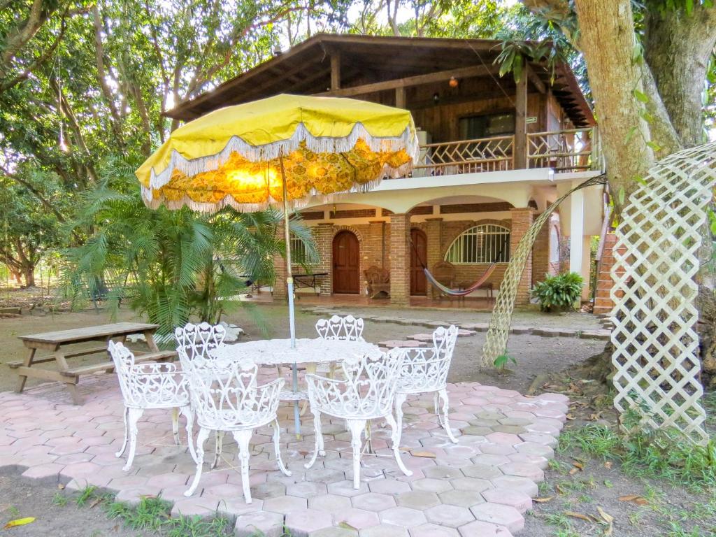 a table and chairs with an umbrella in front of a house at Casa de Agua EcoHotel in Actopan