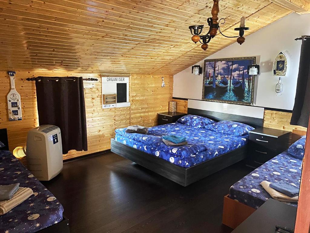 a bedroom with two beds in a room with wooden walls at Casa La Angela in Periprava