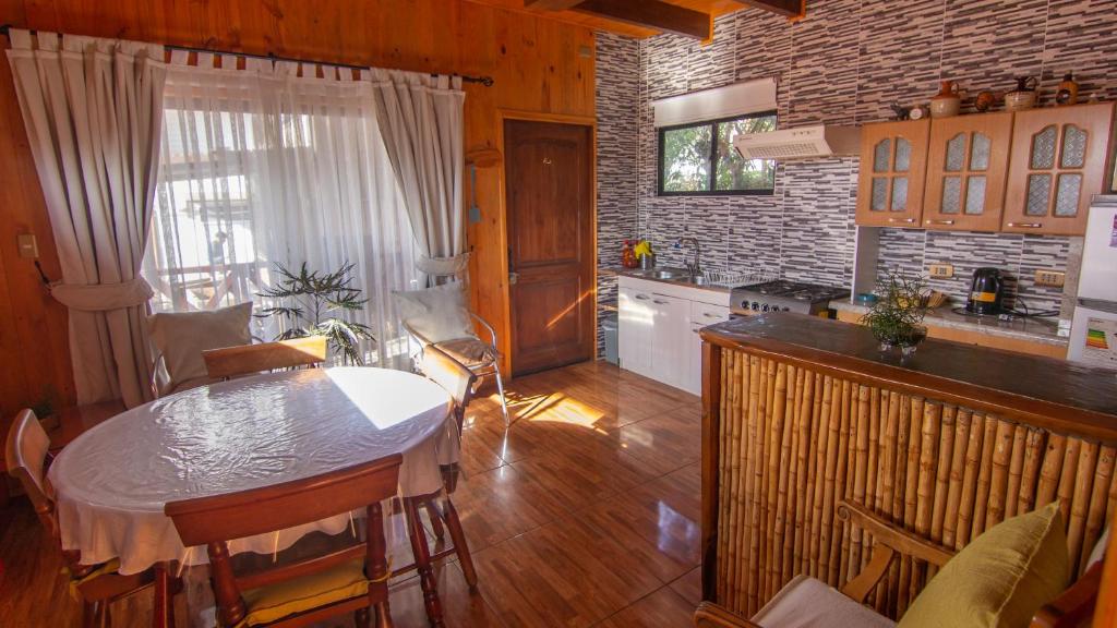 uma cozinha com uma mesa e uma bancada em ELUNEY Pichilemu em Pichilemu