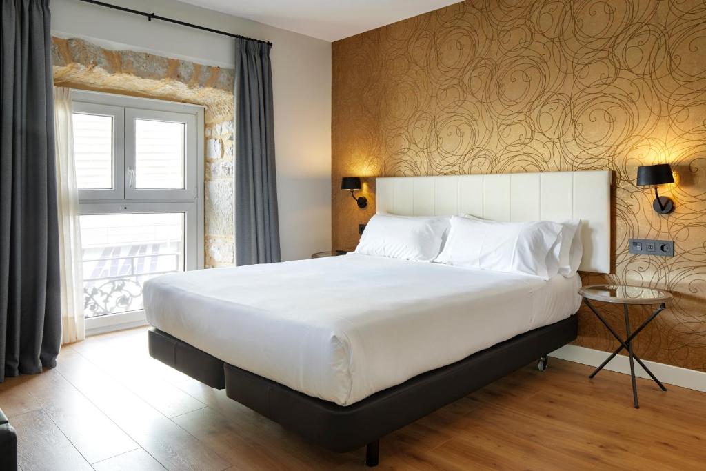 a bedroom with a large bed and a window at Hotel Arrizul Beach in San Sebastián