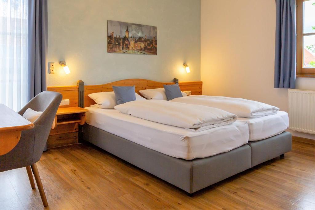 1 dormitorio con 2 camas, escritorio y silla en Hotel am Schwanberg en Rödelsee