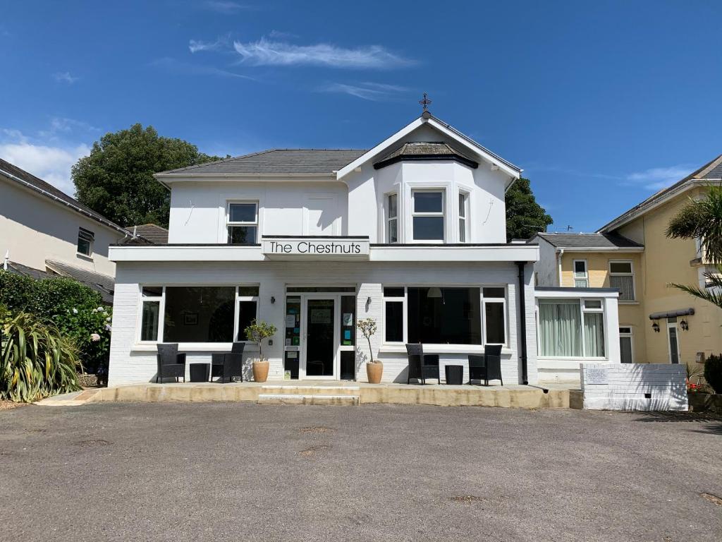 a white building with a sign that reads the office at The Chestnuts in Shanklin