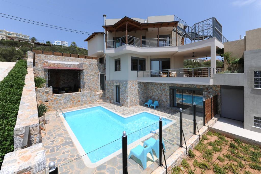 Villa con piscina frente a una casa en Gorgeous Eco Friendly Seaside Villa Nefeli, en Schinias