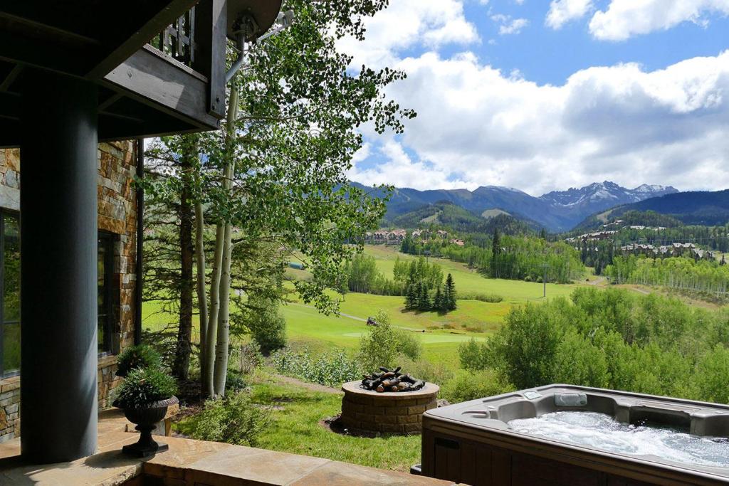 a hot tub on a patio with a view of the mountains at Country Club C & D in Telluride