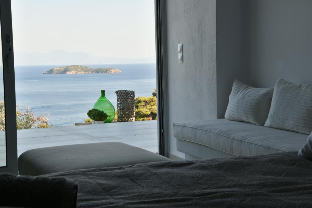 a bedroom with a bed and a view of the ocean at The Hidden Gem in Skiathos
