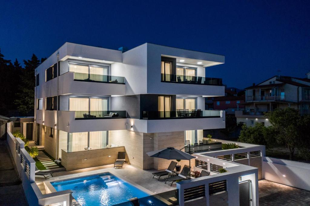 a large white house with a swimming pool at night at Villa Laverna in Novalja