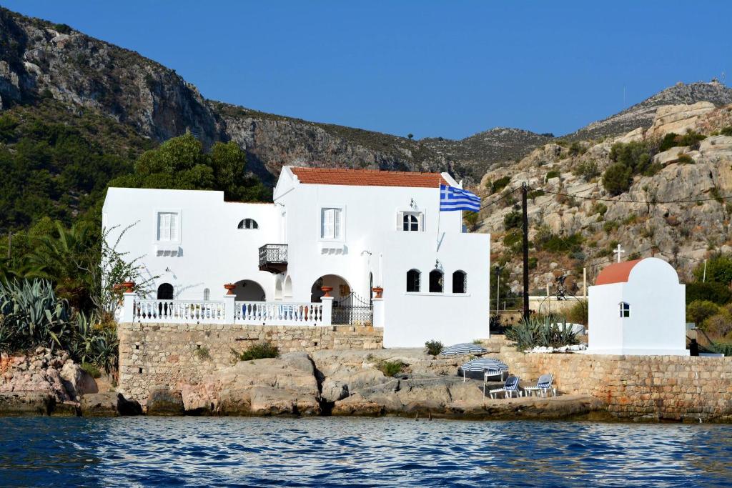 een wit huis aan de kant van het water bij The Admiral's House Kastellorizo in Meyisti