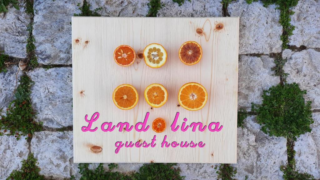 un cartello di legno con quattro fette d'arancia sopra di Landolina Guest House a Donnalucata