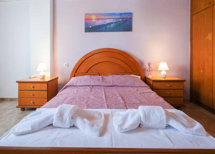 a bedroom with a large bed with two nightstands and two at Μεγάλο Διαμέρισμα Πολυτελείας με θέα την Πόλη in Néa Alikarnassós
