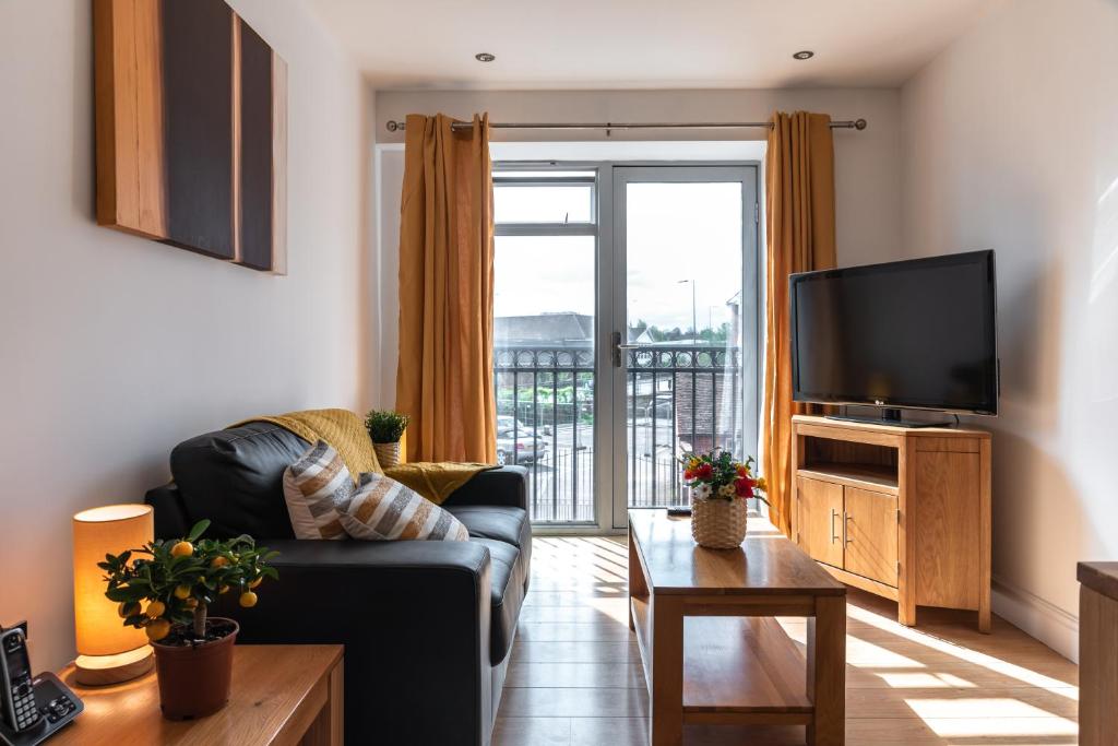 a living room with a couch and a television at The Old Library - Modern apartment with rooftop terrace near the train station in Newbury