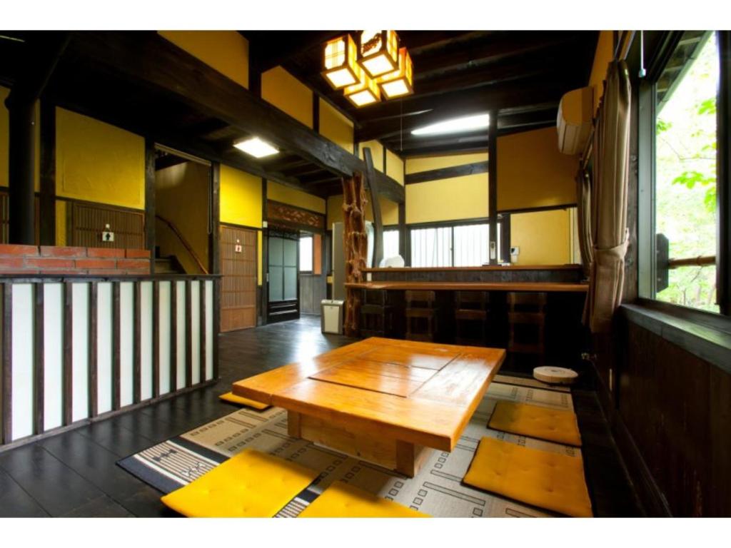 una mesa de madera en el medio de una habitación en Log house for 12 people - Vacation STAY 35072v, en Minamioguni