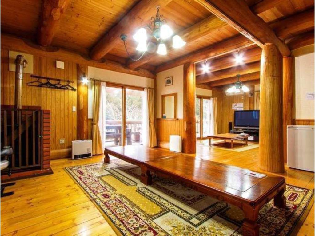 ein Wohnzimmer mit einem Holztisch im Zimmer in der Unterkunft Log house for 12 people - Vacation STAY 33957v in Minamioguni