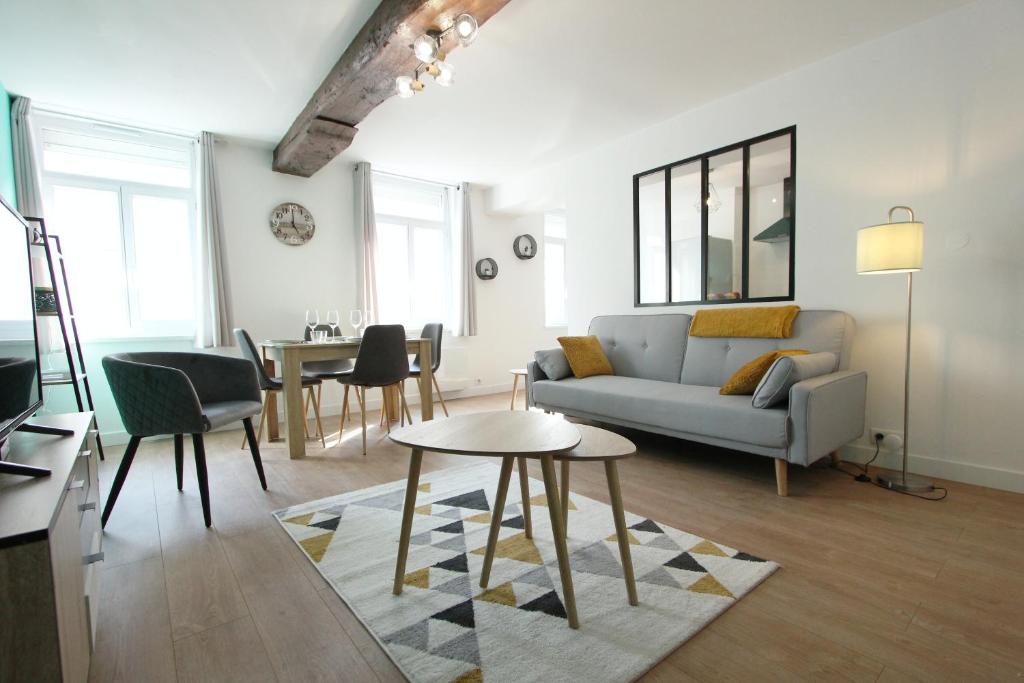 a living room with a couch and a table at Appartement centre de Valenciennes entièrement équipé 64m2 in Valenciennes