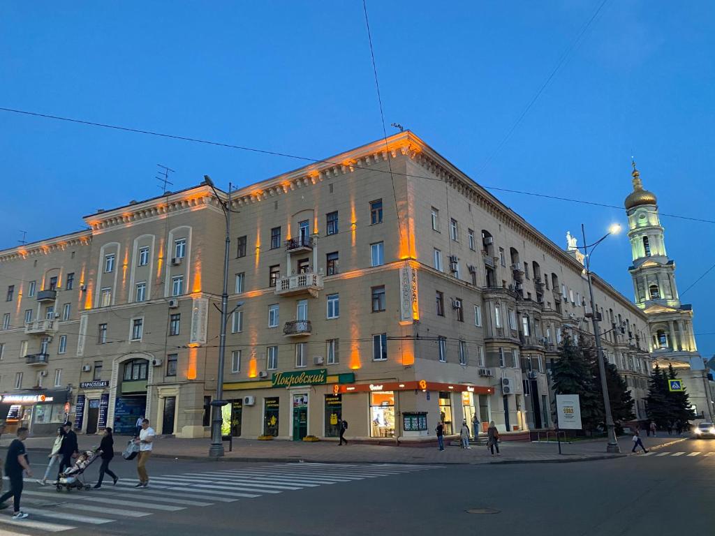 a large building on a city street with a clock tower at Modern luxury studio in the center of Kharkiv at Konstitutsii Square in Kharkiv