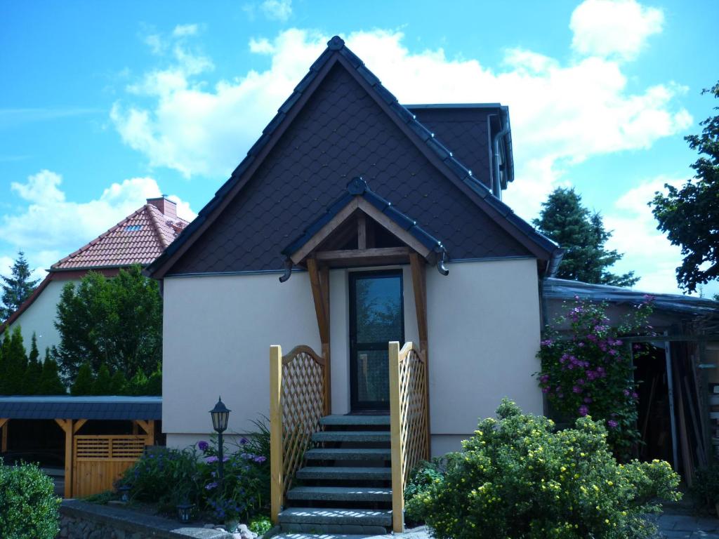 Kleines Ferienhäuschen في Kritzmow: منزل أبيض صغير على سقف أسود