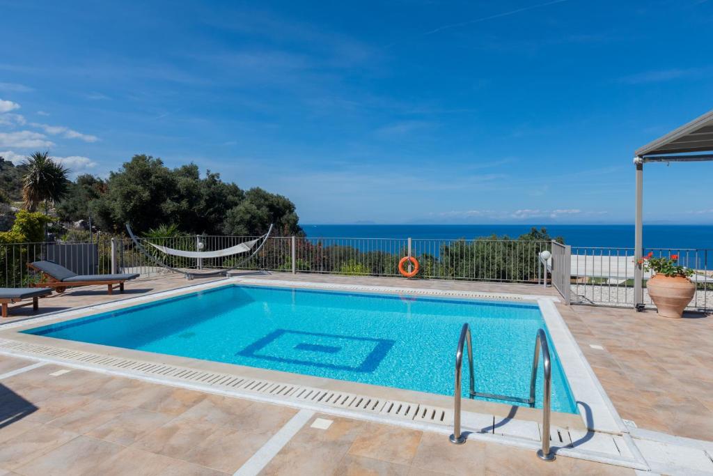 a swimming pool with the ocean in the background at Dalasvillas SkalaAcqua in Skala