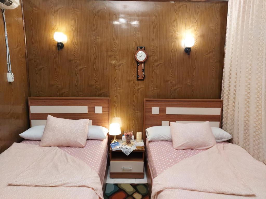 a bedroom with two beds and a clock on the wall at Apartment in the center of Cairo next to the Nile in Cairo