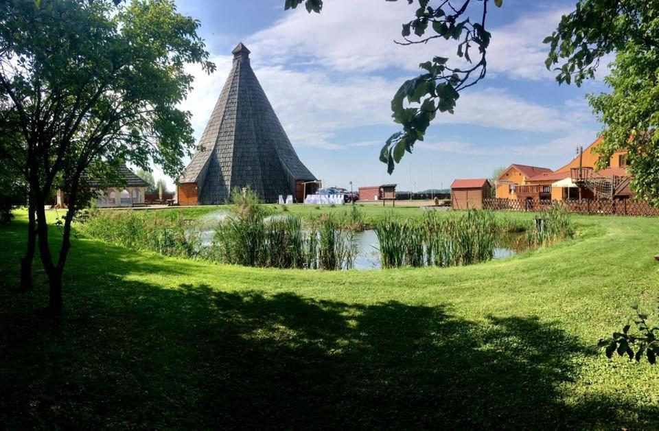 a pyramid building in a park with a pond at Vigvam penzion in Němčice