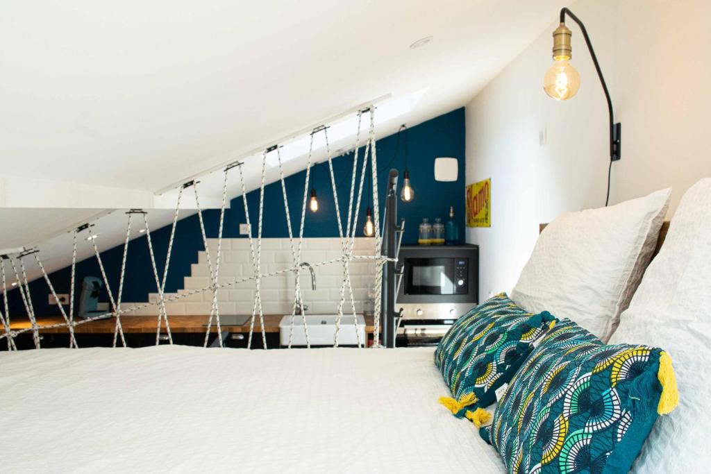 a bedroom with a white bed and a staircase at Appartement atypique au coeur des Alpes in Barraux