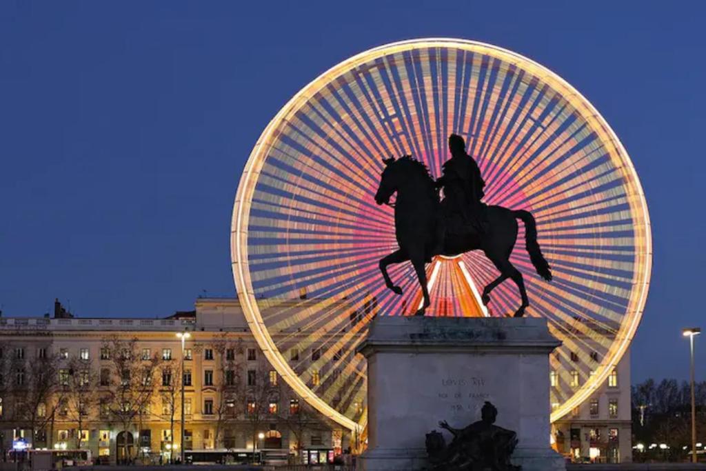 a statue of a man riding a horse in front of a ferris wheel at Appartement atypique au coeur des Alpes in Barraux