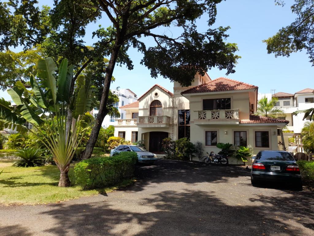 a house with cars parked in front of it at B&B Pavillion in Sosúa