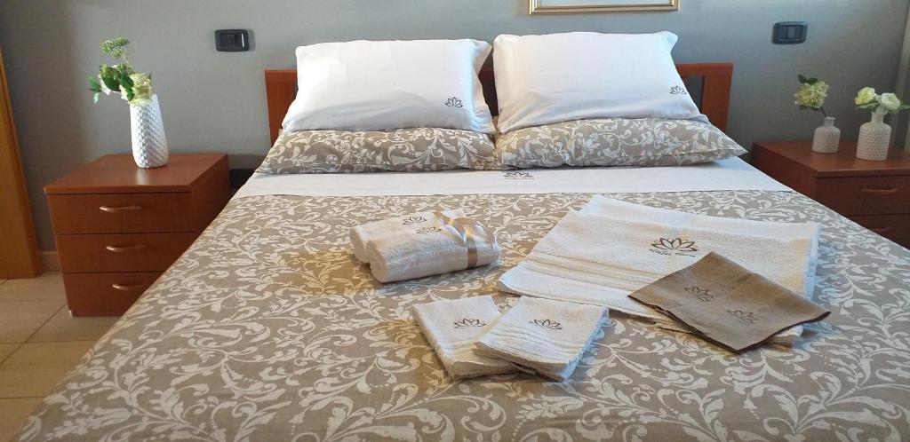 un letto con due cuscini e asciugamani di NINFEA HOUSE a Marina di Montenero