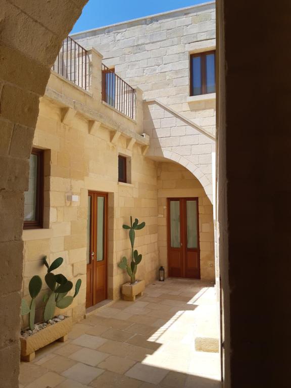 una entrada a una casa de piedra con cactus en Corte Kalìnora, en Martano