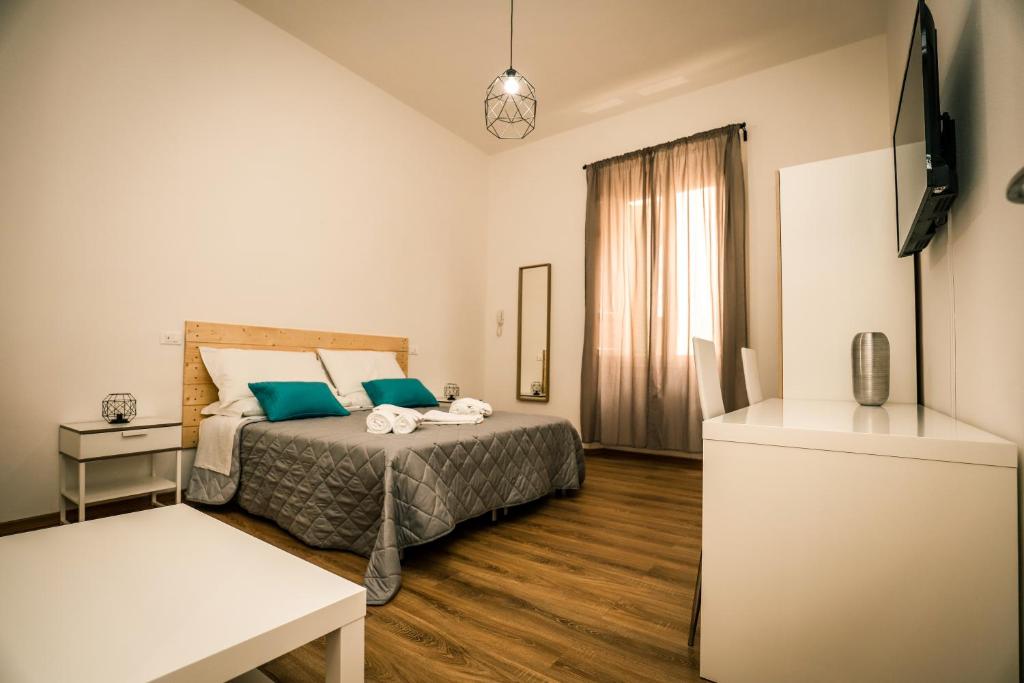 ein Schlafzimmer mit einem Bett mit blauen Kissen in der Unterkunft Hostly - Nicole Apartment Pontedera - 2BR in Full Center in Pontedera
