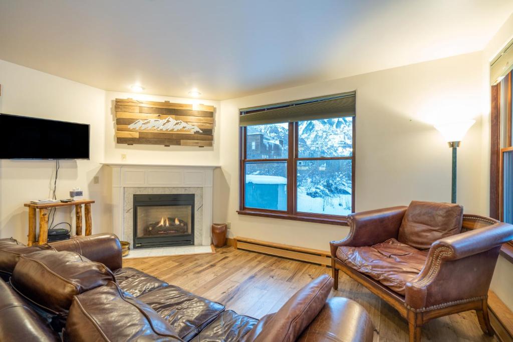 a living room with leather furniture and a fireplace at Ballard South in Telluride