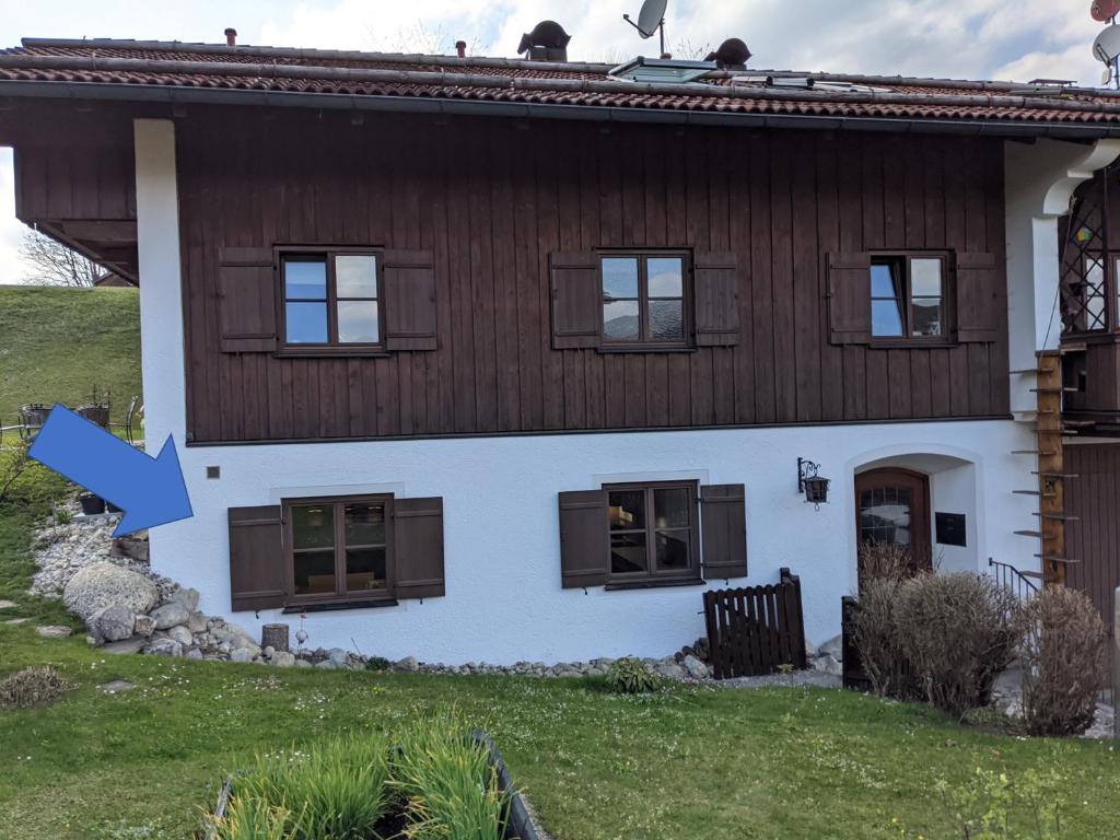Ein Haus mit einem blauen Pfeil, der darauf zeigt. in der Unterkunft Ferienwohnung MonSevi in Wackersberg