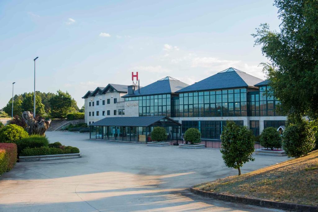 a large building with a parking lot in front of it at Hotel Meson de Erosa in Herosa