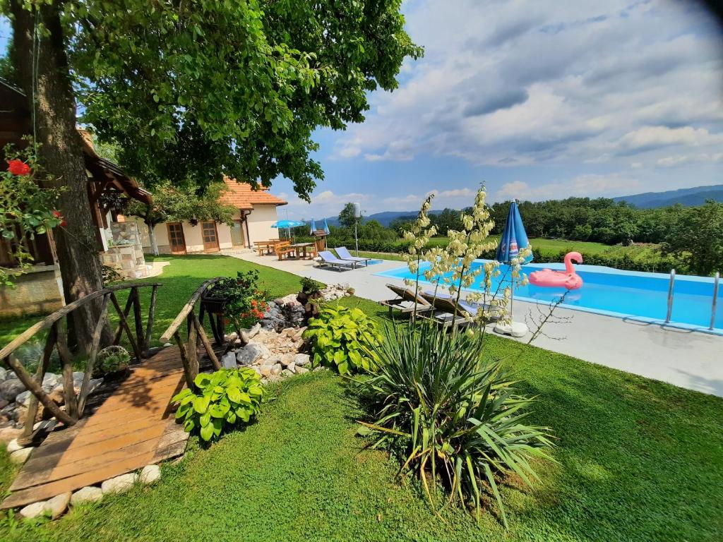 a backyard with a swimming pool and a yard with green grass at Seoski turizam Melovic in Rožanstvo