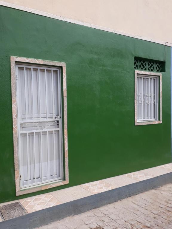 pared verde con puerta y 2 ventanas en Casa acolhedora - aluguel por temporada, en Lençóis