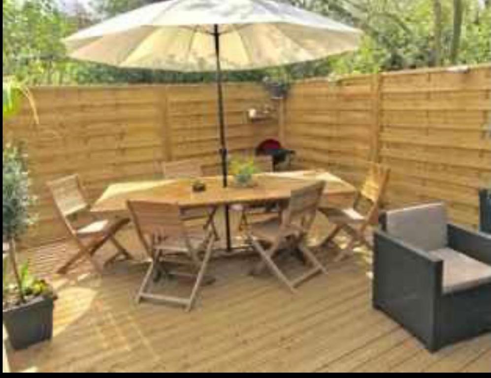 a patio with a table and chairs and an umbrella at Mobilhomme bungalow 6 personnes villeneuve loubet marina baie des anges in Villeneuve-Loubet