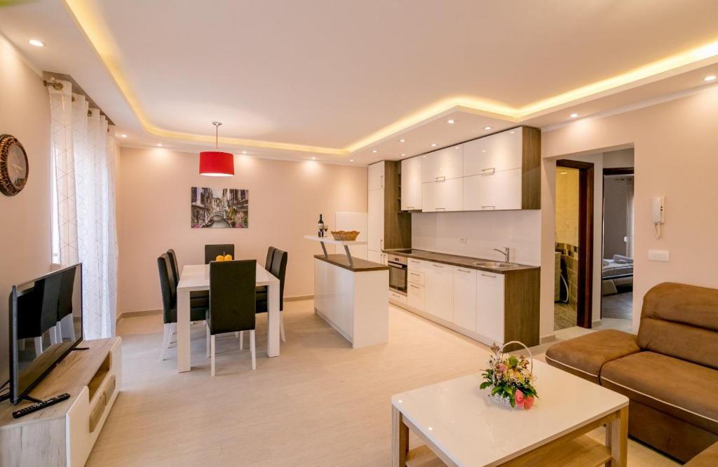 Apartmani Matej في كوتور: غرفة معيشة ومطبخ مع أريكة وطاولة