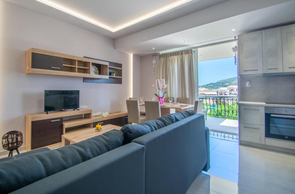 a living room with a blue couch and a kitchen at zakynthos town modern roof apartment in Zakynthos