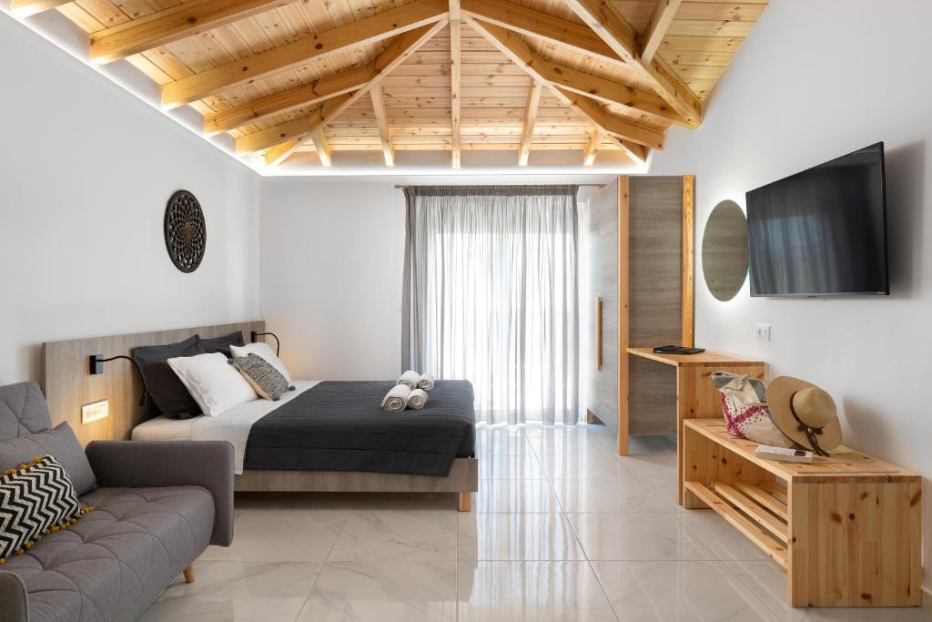 una camera con letto, divano e TV di L & C Boutique Apartments a Kremasti