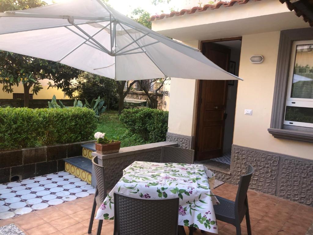 een tafel en stoelen met een parasol op een patio bij William Apartment Sorrento in Sorrento