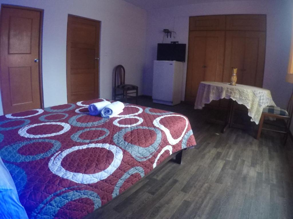 1 dormitorio con 1 cama con manta roja y azul en Residencial Waldorf, en Lima