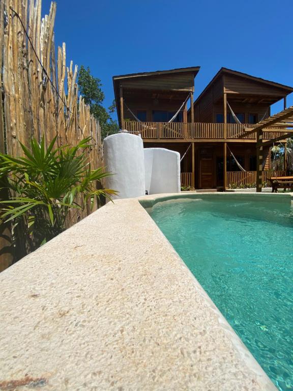 una casa con piscina frente a una casa en Hotel Aruma Ha en Holbox Island