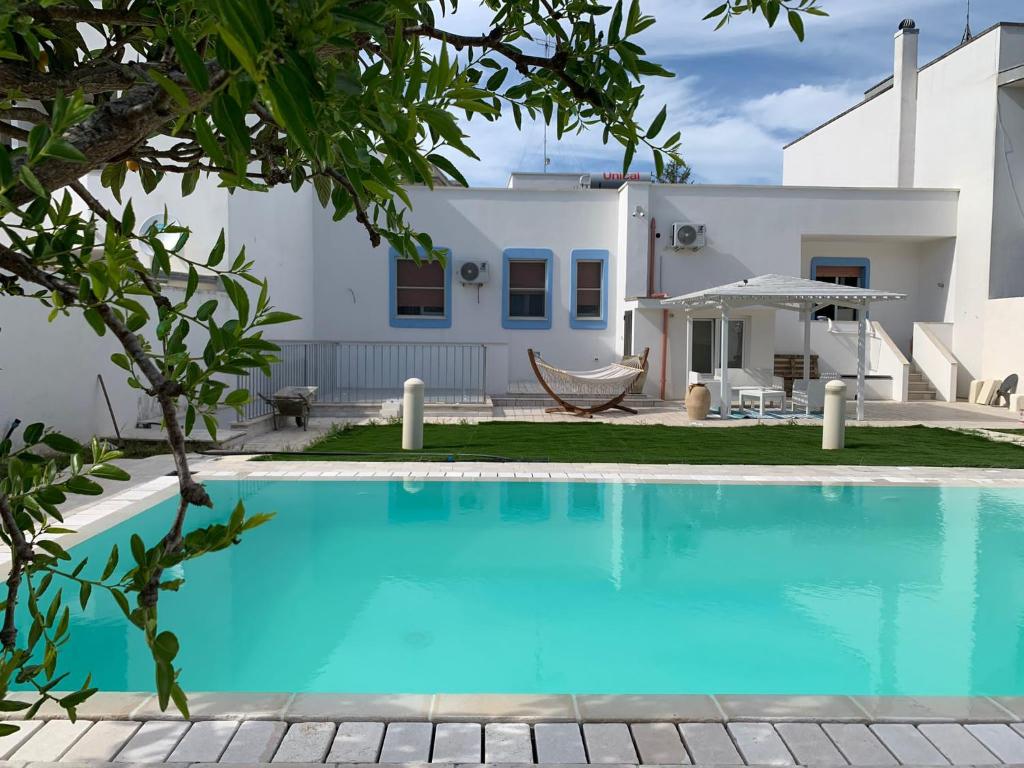 una villa con piscina di fronte a una casa di B&B Villa Ginevra a Otranto