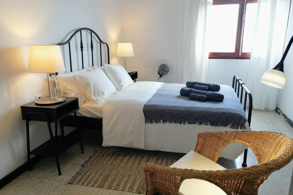 a bedroom with a large bed and a chair at Casa Melchor, amanecer y trabajar mirando al mar in Santa Cruz de la Palma