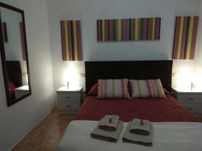 a bedroom with a red bed and a mirror at Casa Relajación in Santa Cruz de Tenerife