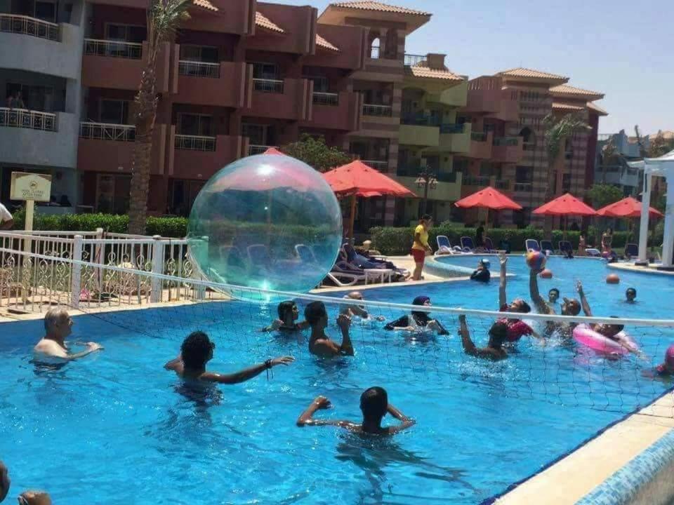 un grupo de personas en una piscina con una gran pelota en el agua en شاليهات بورتو ساوث بيتش عائلات, en Ain Sokhna