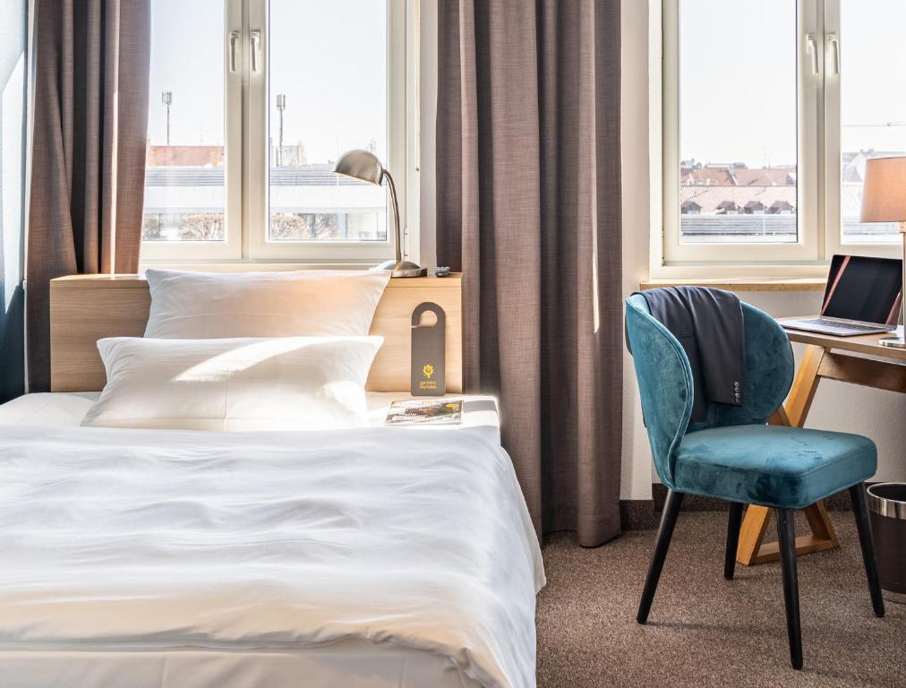 ein Hotelzimmer mit einem Bett, einem Schreibtisch und einem Stuhl in der Unterkunft Hotel Stachus in München